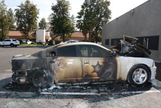 An exterior image of a burned police car.
