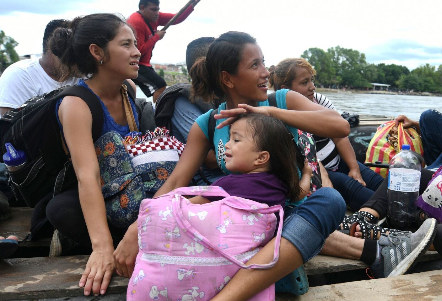 Honduran migrants taking part in a caravan heading to the United States board makeshift rafts to cross the Suchiate River, natural border between Guatemala and Mexico, in Ciudad Tecun Uman, Guatemala.