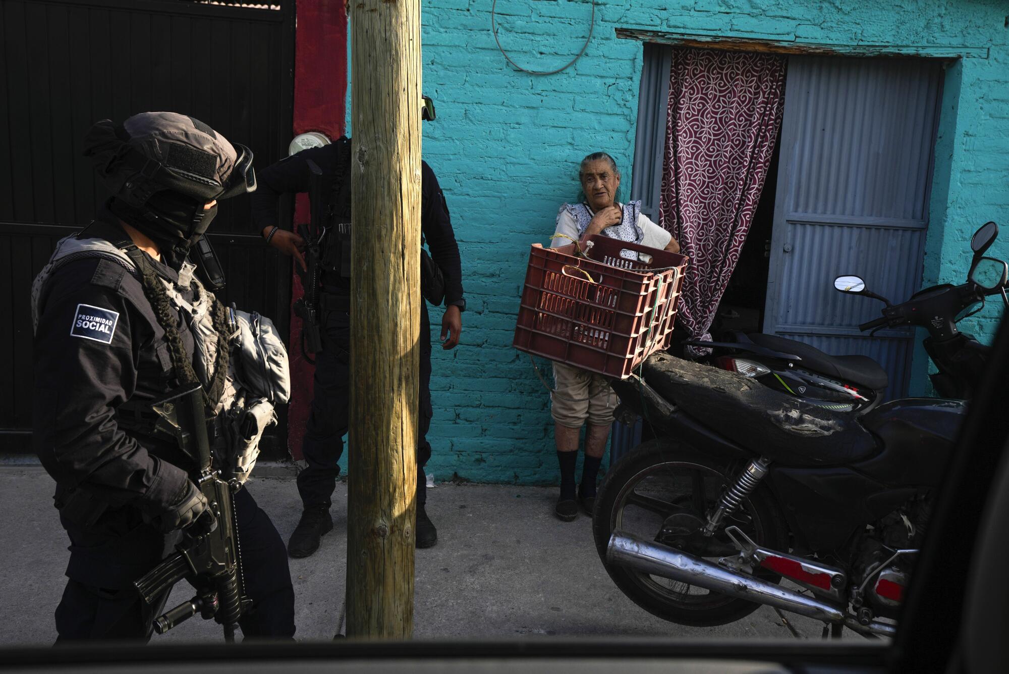 Municipal police chat with a resident while patrolling her neighborhood in Celaya, Mexico.