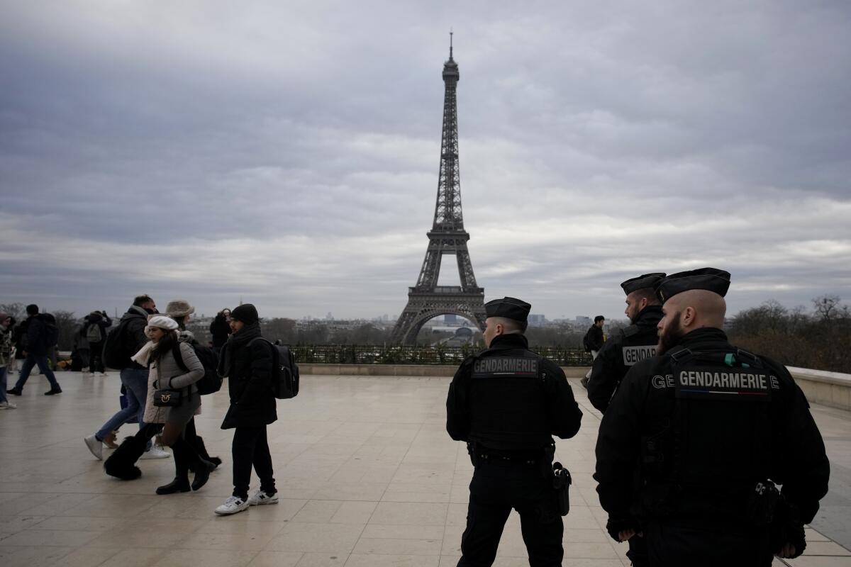 French gendarmes patrol the Trocadero plaza near the Eiffel Tower.