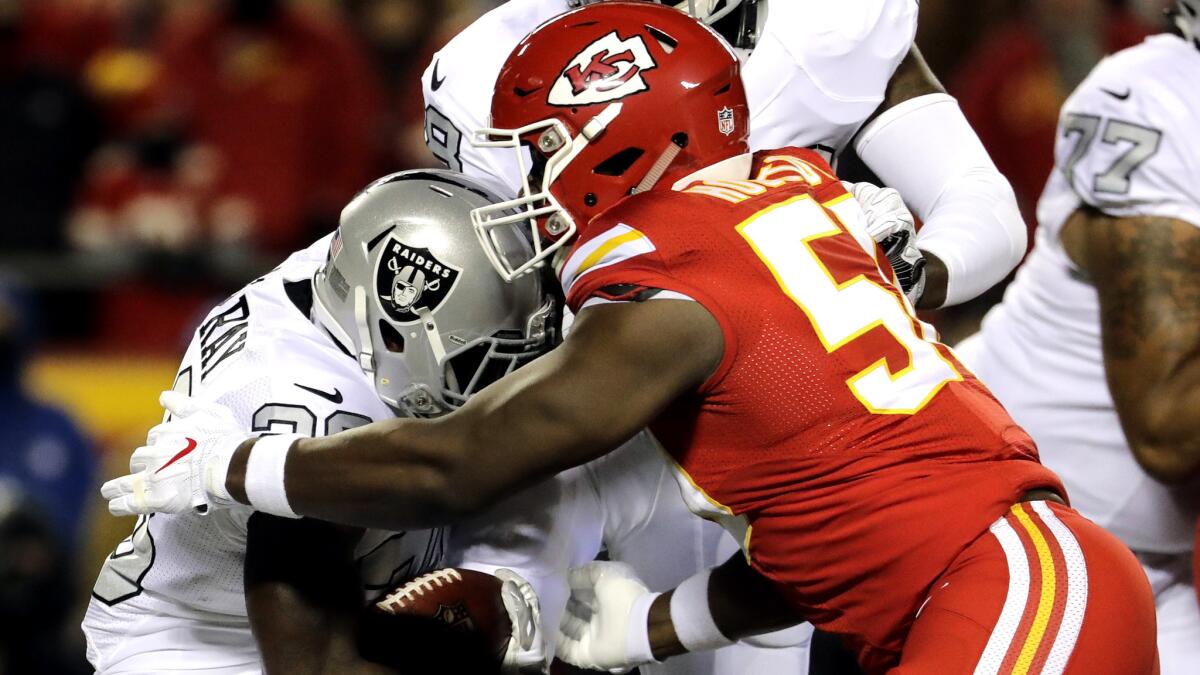 Chiefs linebacker Justin Houston (50) brings down Raiders running back Latavius Murray during the first half of their game Dec. 8.