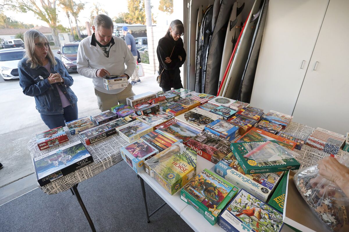 Visitors Friday at Mary Fewel's Costa Mesa garage for a monthly puzzle exchange that attracts people all over the community.