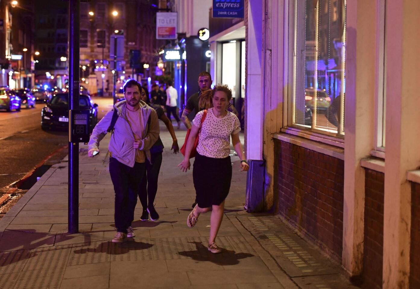 People run down Borough High Street in London after the attack on London Bridge.