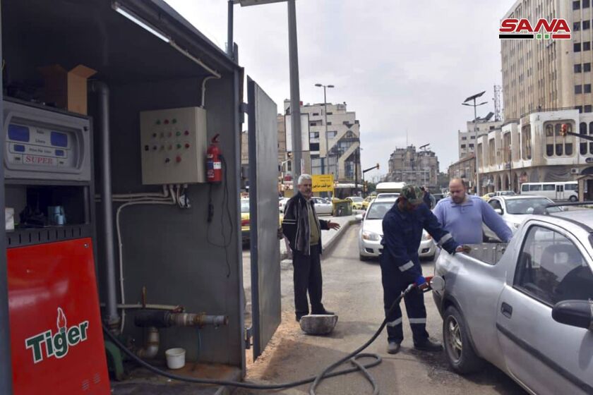 FILE - This file photo released on April 7, 2019, by the Syrian official news agency SANA, shows a worker filling a pickup at a gas station, in Homs, Syria. The Syrian government has decided to close state agencies for two days due to severe fuel shortages caused by disruption of supplies arrivals and Western sanctions imposed on President Bashar Assad’s government. Syrian state media reported Tuesday, Dec. 6, 2022 that the decision to close the institutions on Sunday Dec. 11 and 18, come at a time when many employees have been unable to make it to work because public transport has been badly affected by the crisis. (SANA via AP, File)