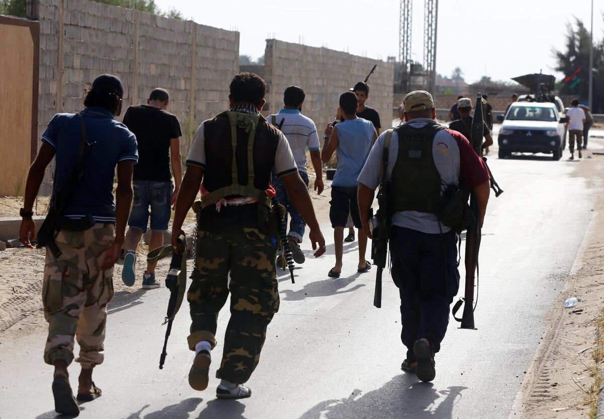 Members of Libya's shield brigade and some local fighters from the western region carry their weapons during clashes with gunmen accused of being loyal to the former regime.