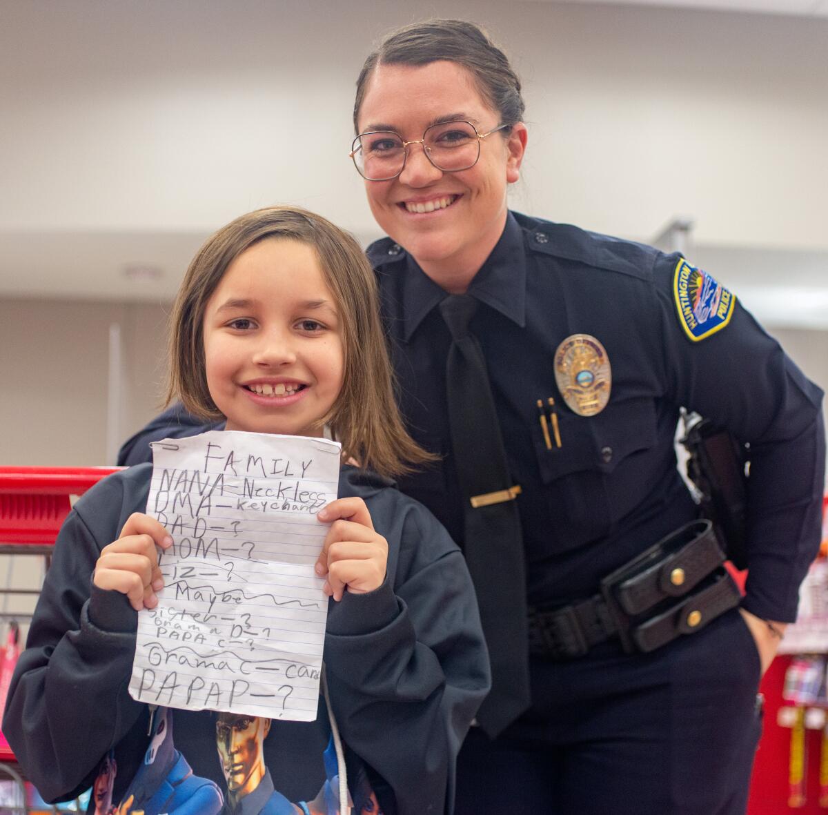 Jaxon Seidl poses for a photo with Officer Aubrey Jensen during Shop With a Cop on Wednesday.