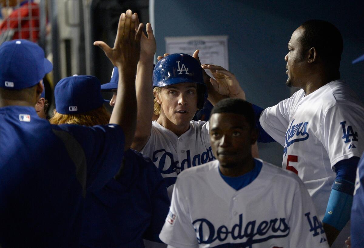 Dodgers pitcher Zack Greinke (in helmet) is congratulated by teammates after scoring the team's second run in the third inning of Game 2 against the Cardinals.