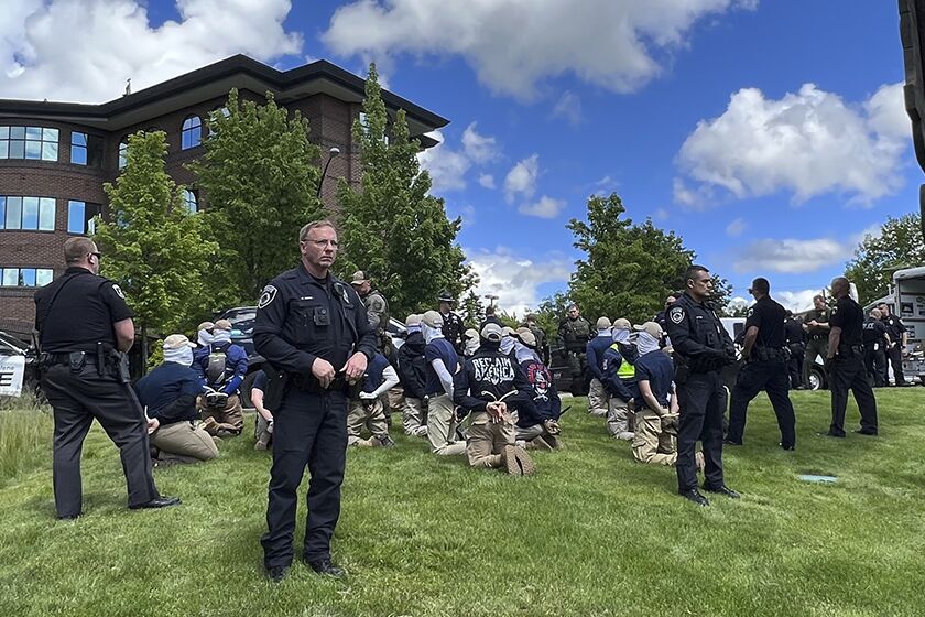Police guard members of a white supremacist group after their arrests Saturday in Coeur d’Alene, Idaho.