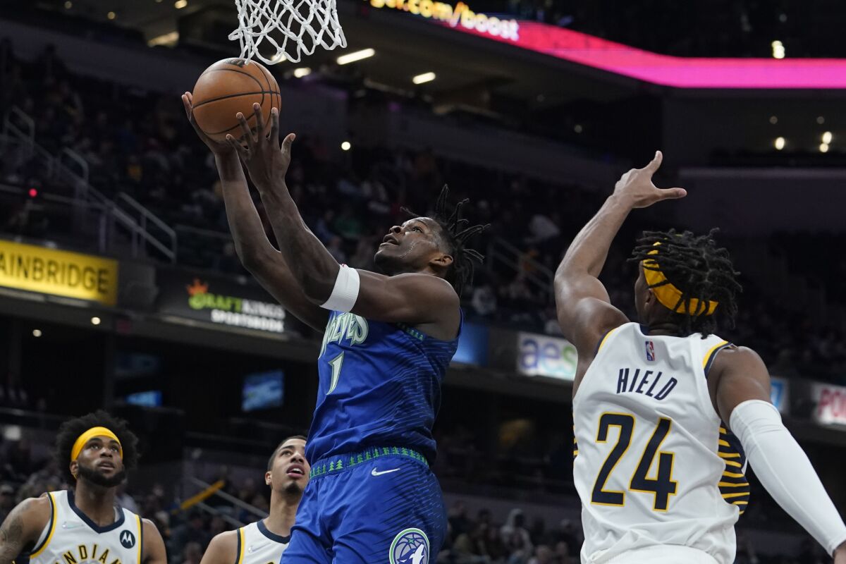 Minnesota Timberwolves' Anthony Edwards (1) shoots against Indiana Pacers' Buddy Hield (24) during the first half of an NBA basketball game, Sunday, Feb. 13, 2022, in Indianapolis. (AP Photo/Darron Cummings)