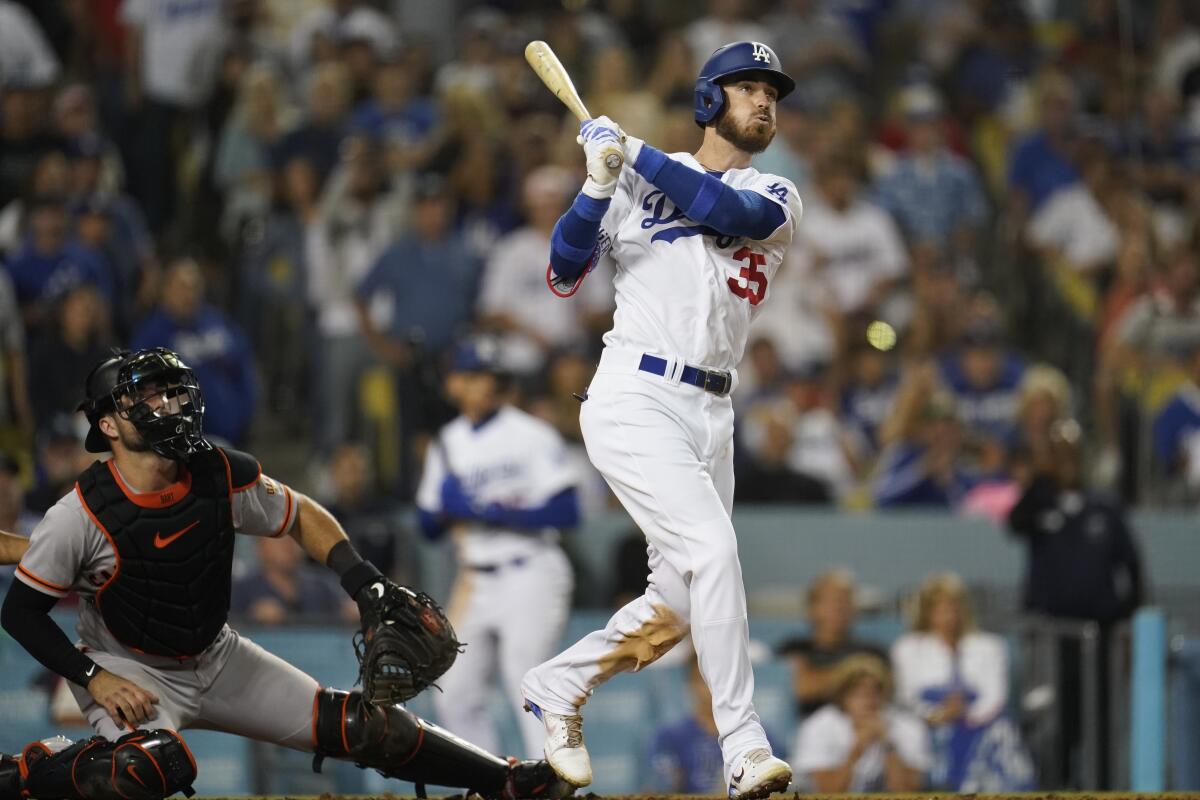 Cody Bellinger follows through on his grand slam swing during the eighth inning Friday.