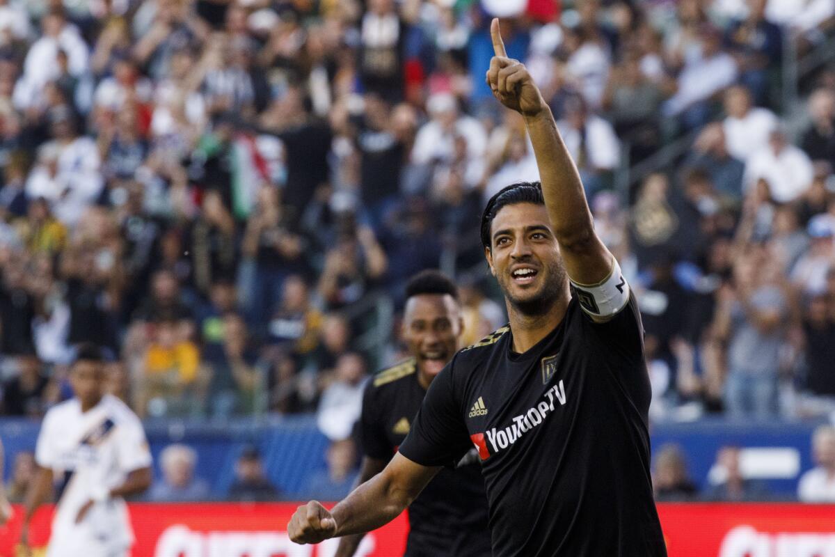 Los Angeles FC forward Carlos Vela raises a hand in celebration.