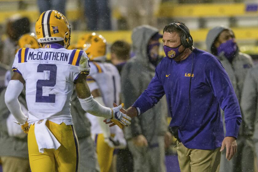 LSU cornerback Dwight McGlothern (2) celebrates a play with LSU head coach Ed Orgeron against Mississippi during the second half an NCAA college football game in Baton Rouge, La., Saturday, Dec. 19, 2020. (AP Photo/Matthew Hinton)