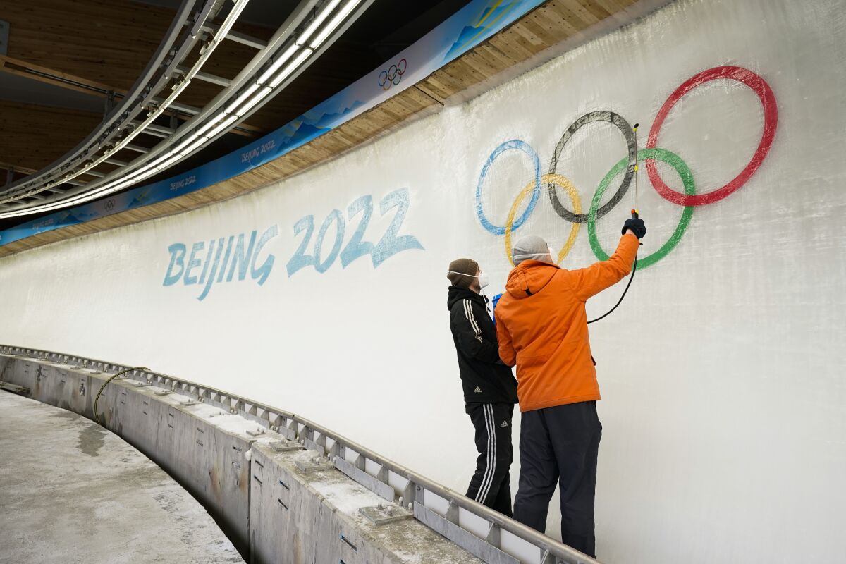 Workers prepare the ice at the Yanqing National Sliding Center after installing a logo on the track.