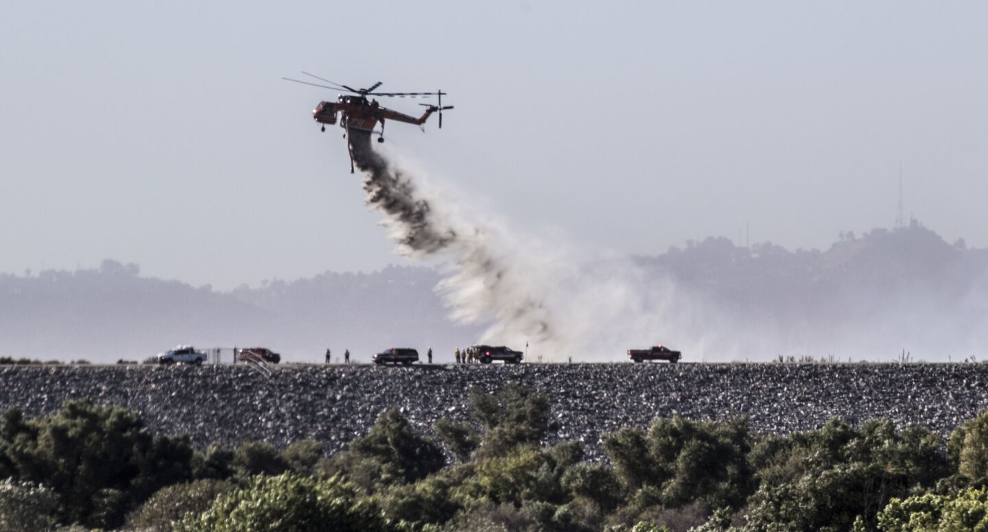 Los Angeles city and county firefighters work to put out a brush fire at the Hansen Dam Recreation Area in Pacoima.