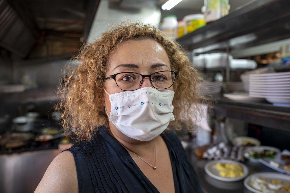 Milbet Del Cid wears a face mask in a restaurant kitchen
