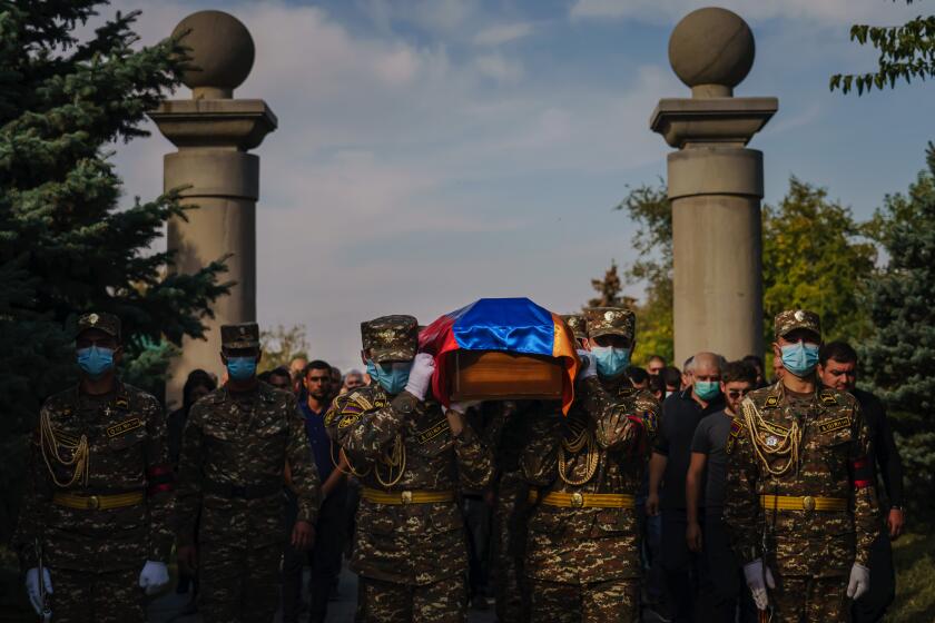 YEREVAN, ARMENIA -- OCTOBER 15, 2020: Armenian soldiers ceremoniously transport the caskets of Kristapor Artin and Suren Vanyan, both volunteer fighters who lost their lives to the Nagorno-Karabakh war, to their burial sites at the Yerablur Military Memorial Cemetery in Yerevan, Armenia, on Thursday Oct. 15, 2020. The conflict, which began on Sept, 27, is between Azerbaijani and Armenian forces over Nagorno-Karabakh D a disputed region, which is also internationally recognized as part of Azerbaijan D has killed hundreds including dozens of civilians from both sides, and the death toll continues to mount. (Marcus Yam / Los Angeles Times)