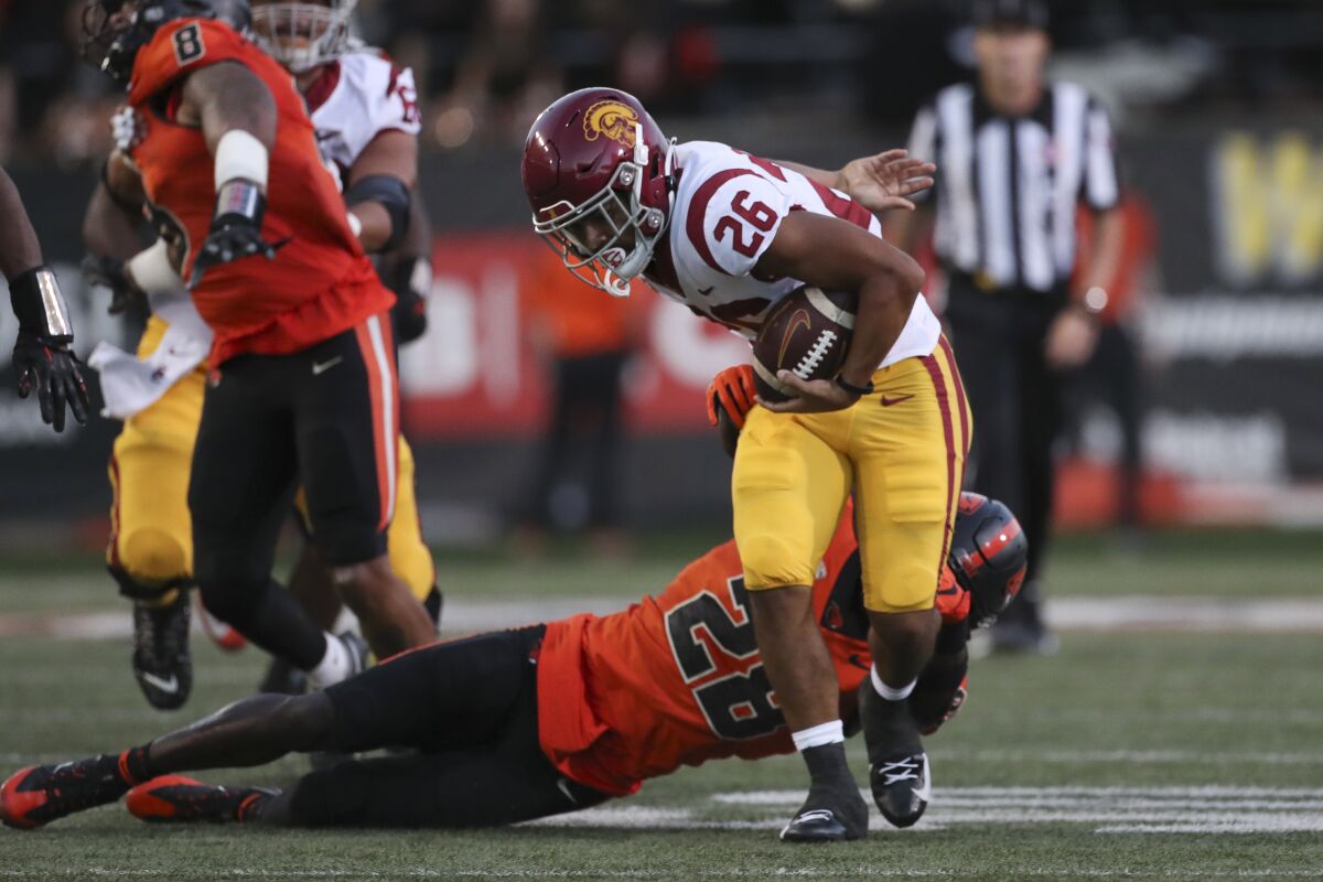 USC running back Travis Dye slips a tackle by Oregon State defensive back Kitan Oladapo during the first half.