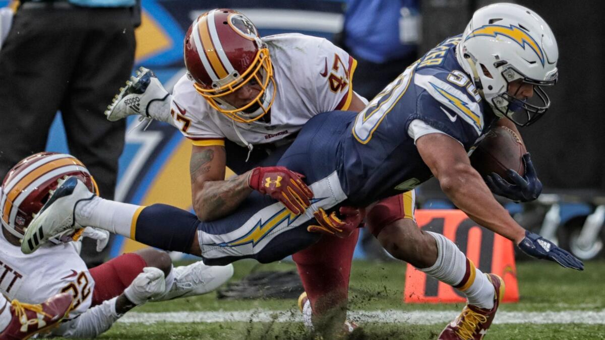 Chargers running back Austin Ekeler is tackled in bounds by Redskins cornerback Quniton Dunbar as the clock runs out on the first half at Stubhub Center.