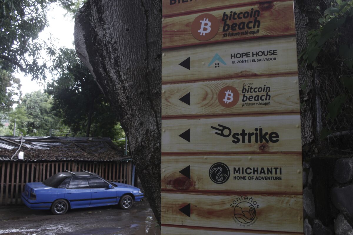 A sign that advertises the acceptance of cryptocurrencies at local businesses stands at one of the entrances of Zonte Beach in Tamanique, El Salvador, Wednesday, June 9, 2021. El Salvador's Legislative Assembly has approved legislation making the cryptocurrency Bitcoin legal tender in the country, the first nation to do so, just days after President Nayib Bukele made the proposal at a Bitcoin conference. (AP Photo/Salvador Melendez)