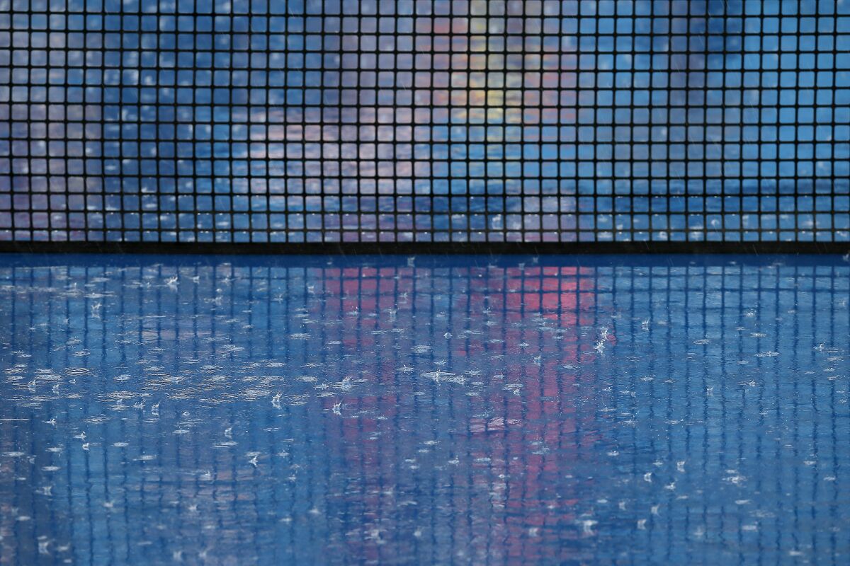 Heavy rain falls and suspends play in the second set of a match between Cameron Norrie and John Isner in the Western & Southern Open tennis tournament in Mason, Ohio, Tuesday, Aug. 17, 2021. (Sam Greene/The Cincinnati Enquirer via AP)