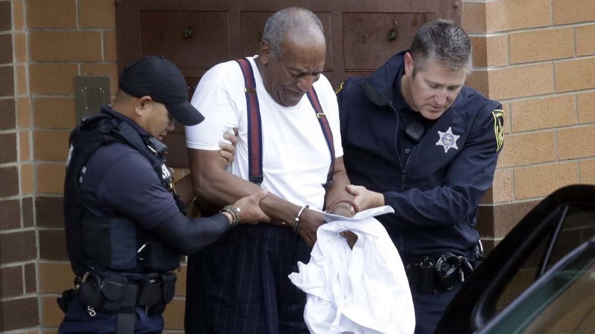 A handcuffed Bill Cosby is escorted out of the Montgomery County Correctional Facility in Eagleville, Pa., in September 2018 after being sentenced for sexual assault.