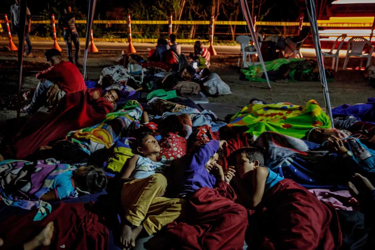 Niños venezolanos duermen bajo delgadas lonas de plástico en un campamento en Bochalema, Colombia, después de llegar con sus familias a pie.