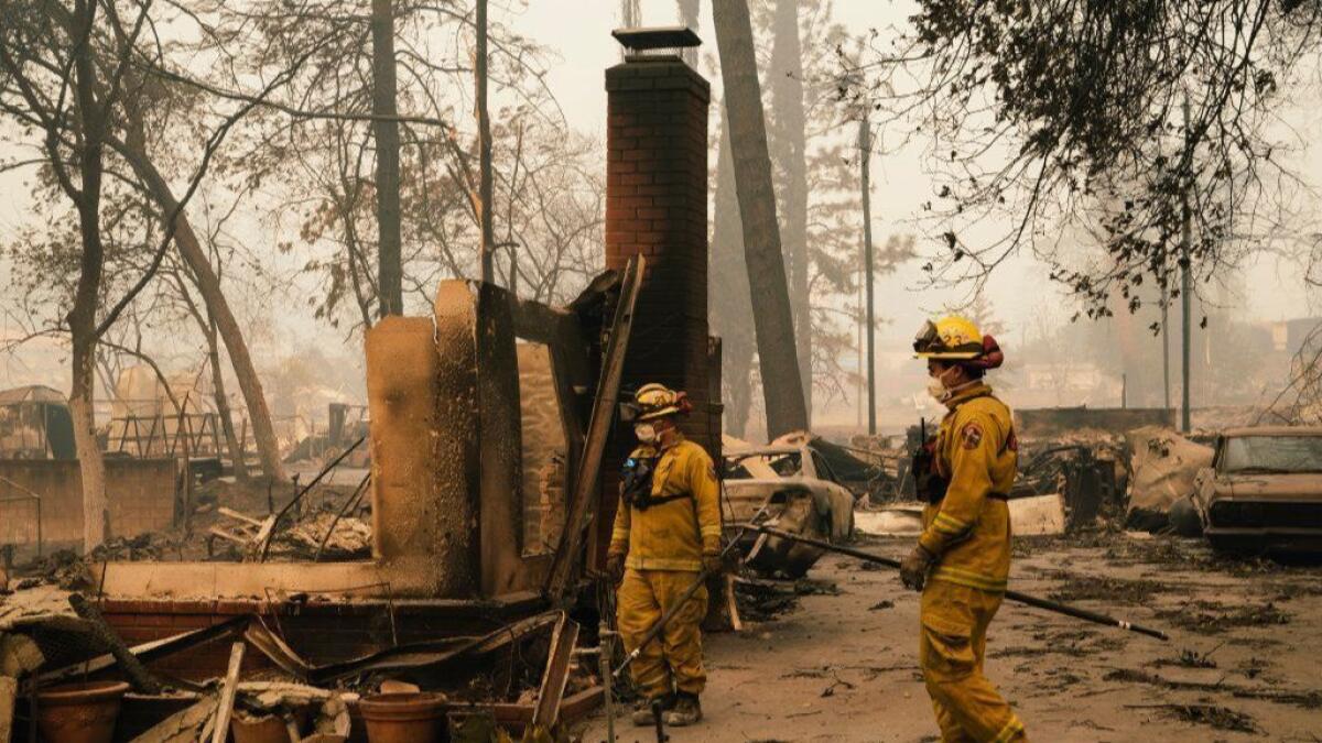 Cal fire crews walk through the rubble of homes in Paradise, Calif., on Nov. 10, putting out hot spots.