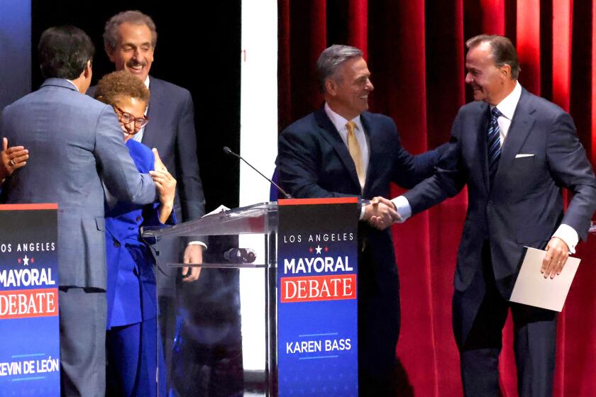 LOS ANGELES, CA - MARCH 22: Mayoral candidates Kevin de Leon, left, Karen Bass, Mike Feuer, Joe Buscaino and Rick Caruso greet each other after the mayoral debates at USC's Bovard Auditorium on Tuesday, March 22, 2022 in Los Angeles, CA. (Myung J. Chun / Los Angeles Times)