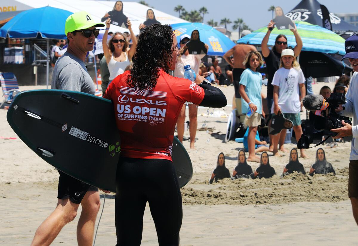 Nolan Rapoza of Long Beach gets a quick drink of water as he runs to shore in the middle of his heat.