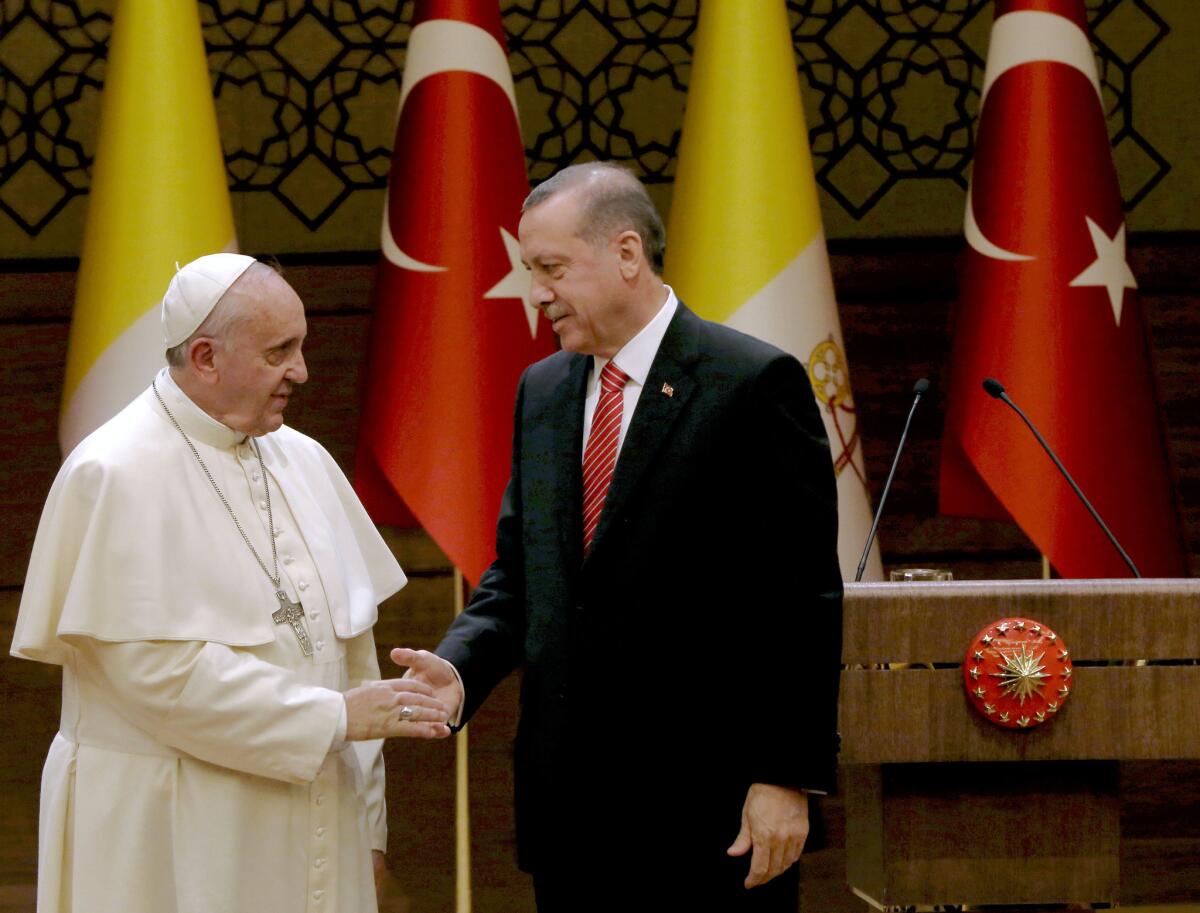 Pope Francis, left, shakes hands with Turkish President Recep Tayyip Erdogan at the presidential palace in Ankara on Nov. 28.