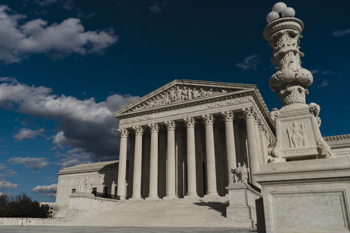 The front of the Supreme Court building against a cloudy dark-blue sky