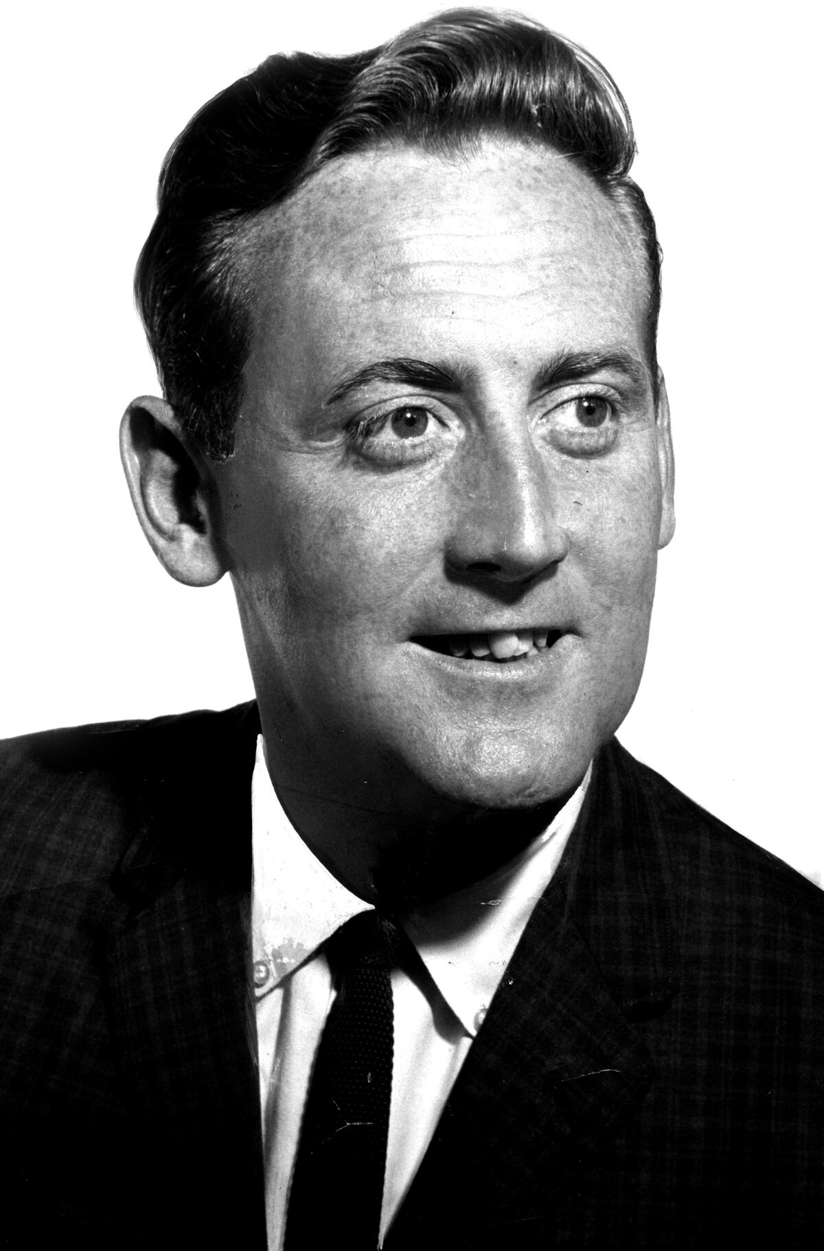 A headshot of a man in a suit and tie
