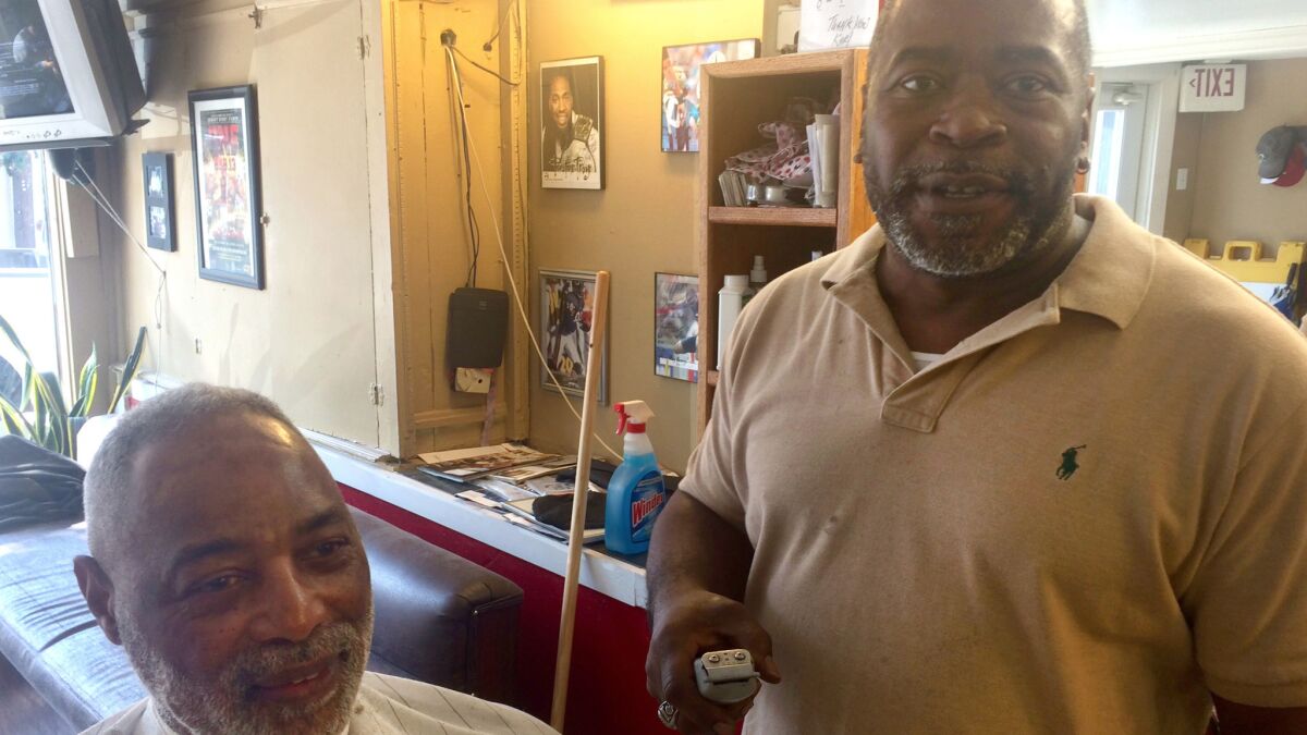 Atlanta barber Karl Booker is strongly behind Hillary Clinton. But customer Dwight Cole wants to hear more about what she would do to help African Americans.