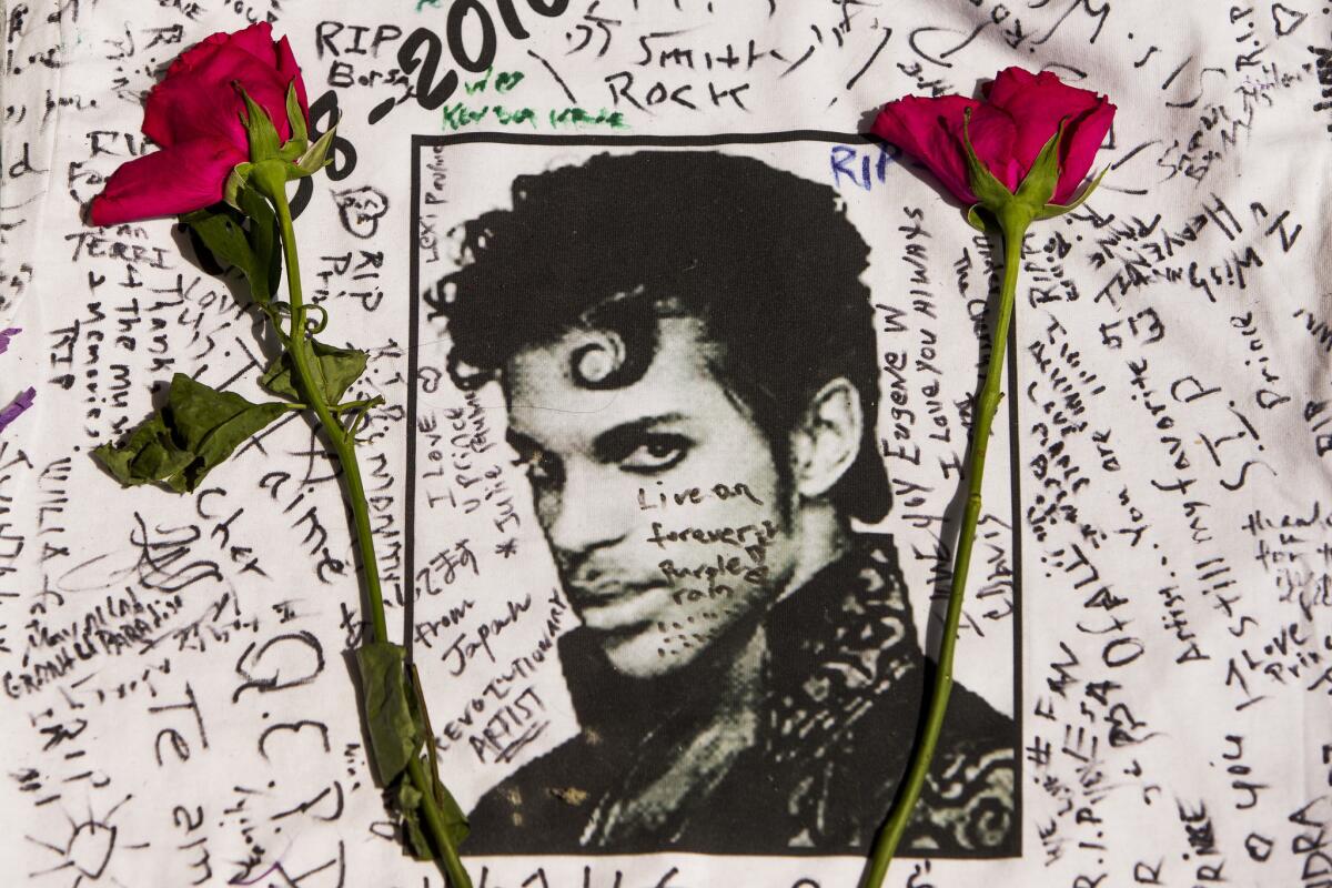 Flowers lay on a T-shirt signed by fans of singer Prince at a makeshift memorial outside the Apollo Theatre in New York on Friday.