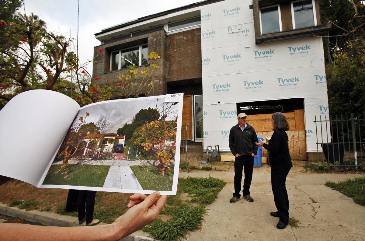 Traci Considine holds a "before" photo of a home under construction in her Faircrest Heights neighborhood that she believes is an example of mansionization on March 14, 2014.
