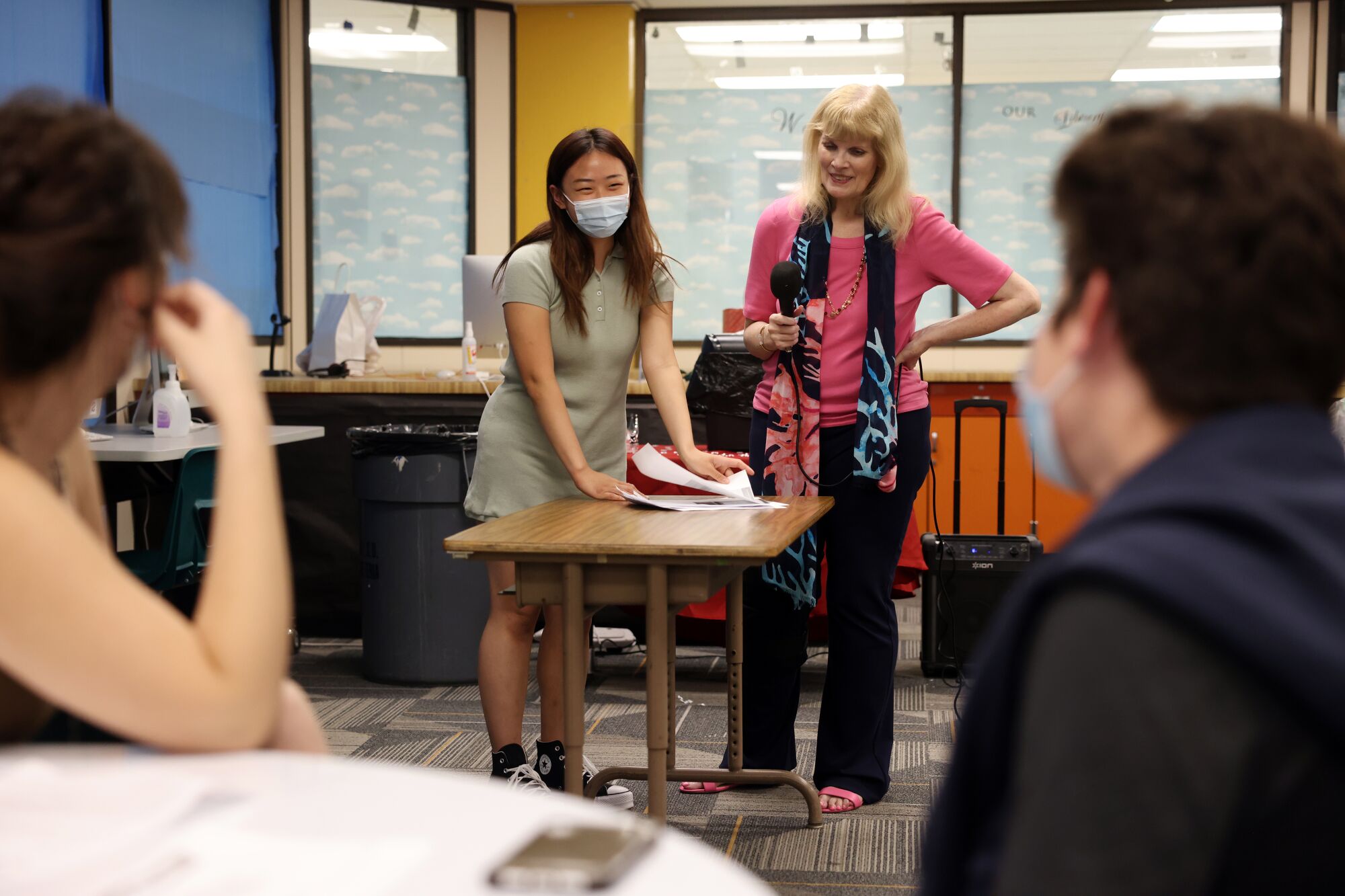 A high school senior stands next to her college counselor in school offices.