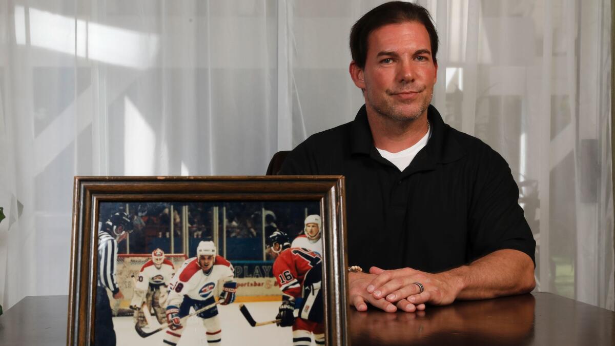 Eric Lemarque sits at home with a photo of himself playing for the Greensboro (N.C.) Monarchs during the 1991-92 season.