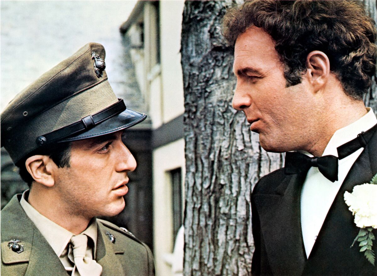 A man in a uniform, talks to a man in a tuxedo in a scene from the film “The Godfather.” 