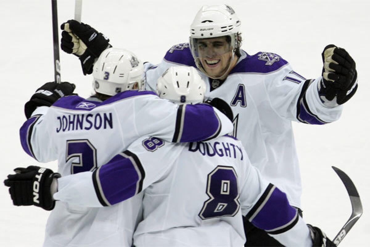 Drew Doughty (8) is congratulated by Jack Johnson (3) and Anze Kopitar after scoring the game-winning goal against the New Jersey Devils on Jan. 31, 2010, part of a franchise-record nine-game winning streak.