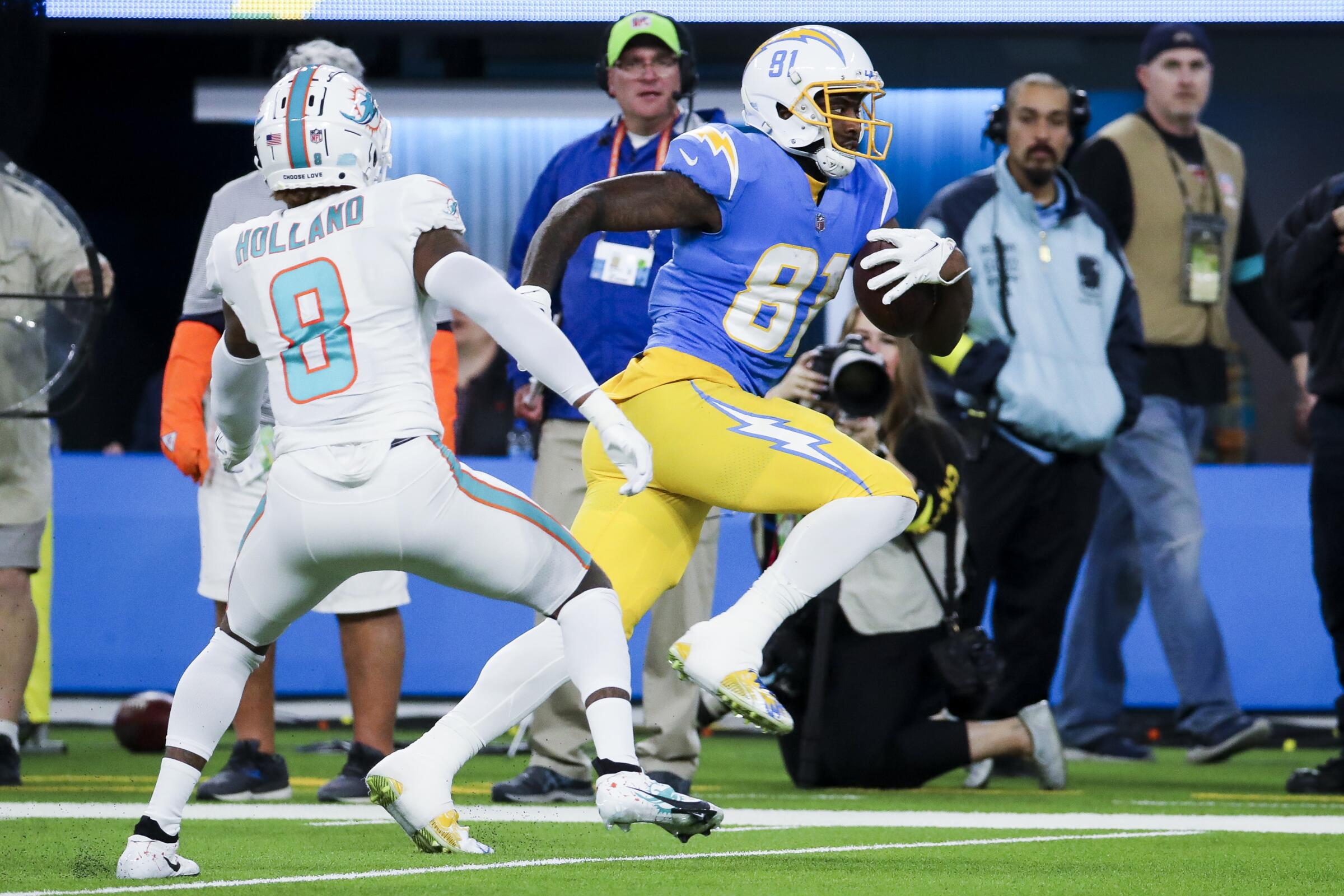 Chargers wide receiver Mike Williams runs past Miami Dolphins safety Jevon Holland after a catch Dec. 11, 2022. 