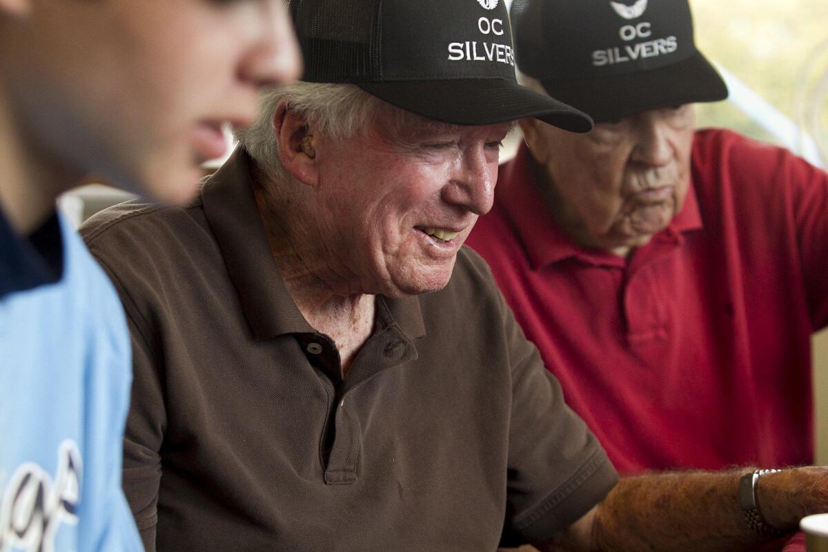 Ed Isenberg, a resident at Crown Cove assisted living facility, enjoys a game of 21 with members of the Corona del Mar High baseball team on Saturday.