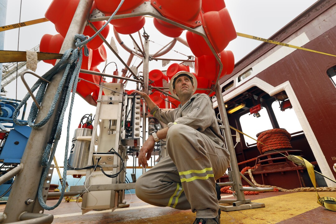 Andrew K. Sweetman with a machine used to collect samples from the seabed.