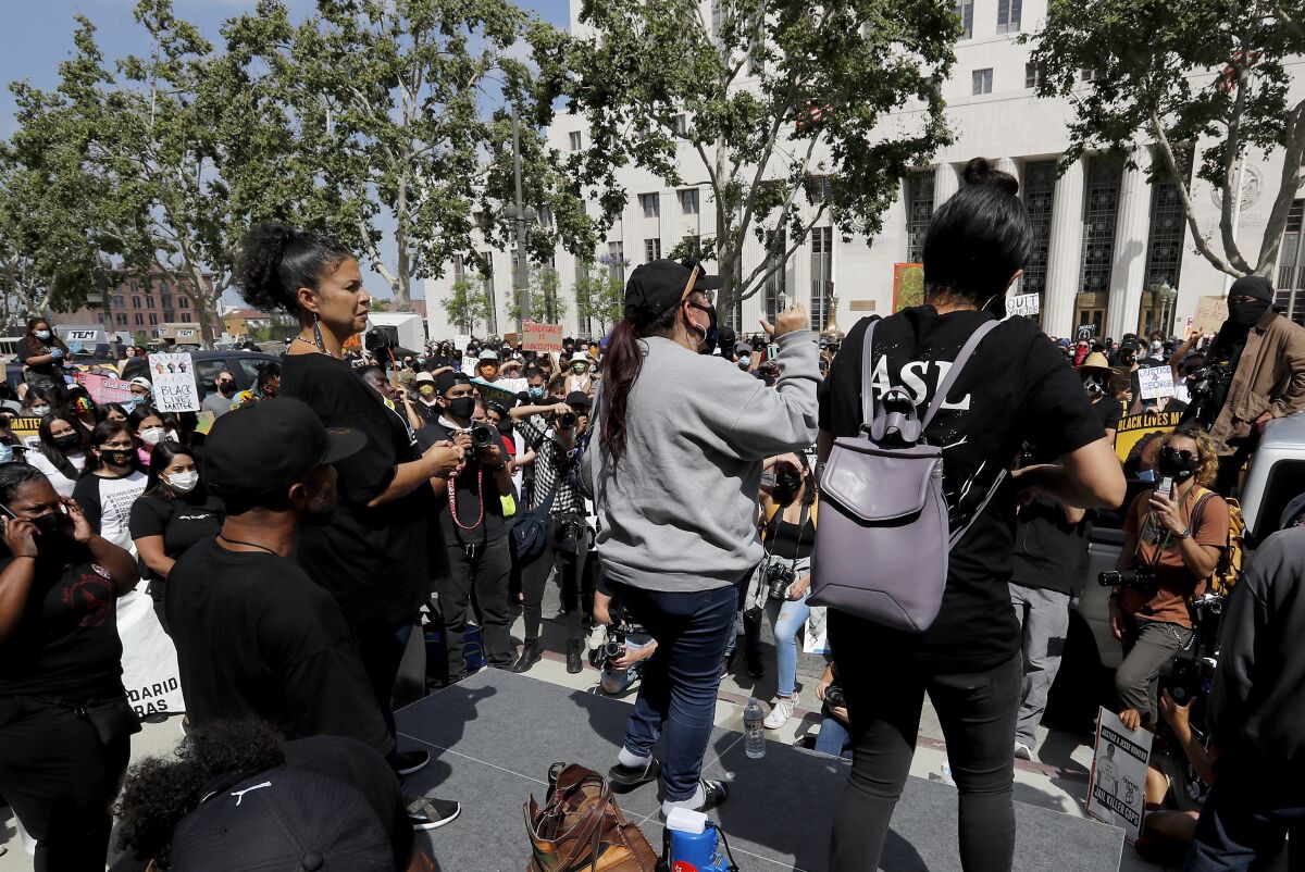 Melina Abdullah stands onstage as protesters rally outside the Hall of Justice in downtown Los Angeles
