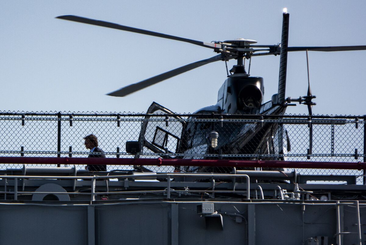 Actor Tom Cruise exits a helicopter on the deck of the USS Midway Museum.
