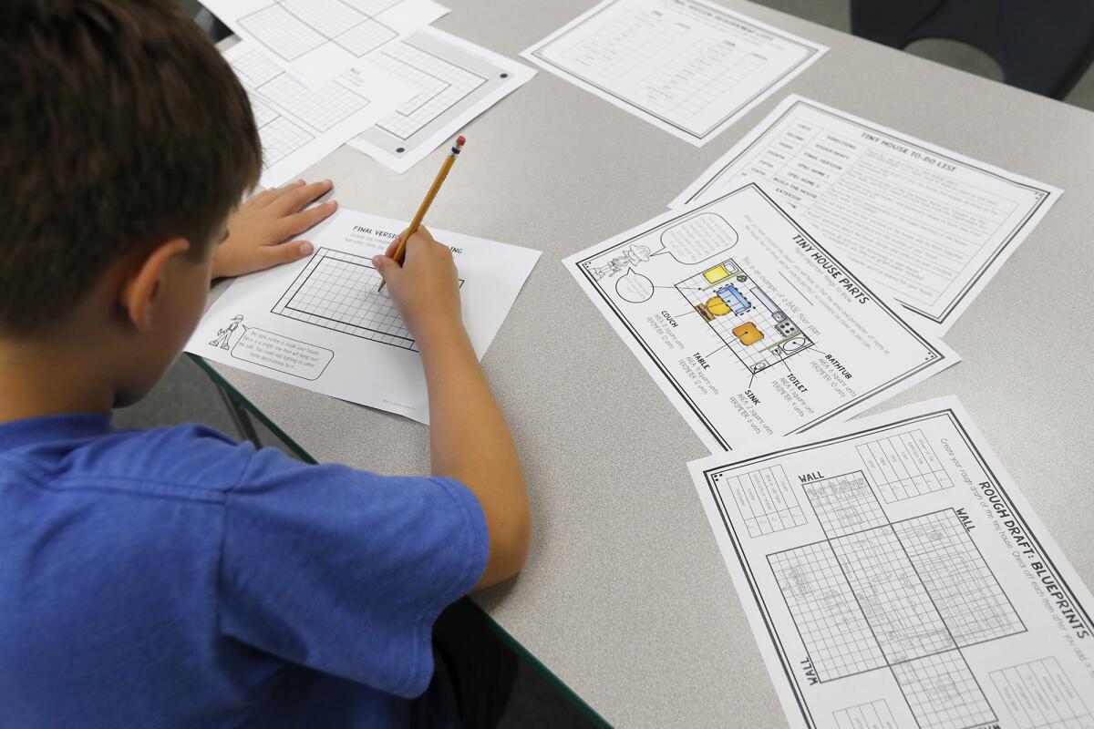 A fourth-grader works on creating a tiny house at the STEM3 Academy in Irvine.