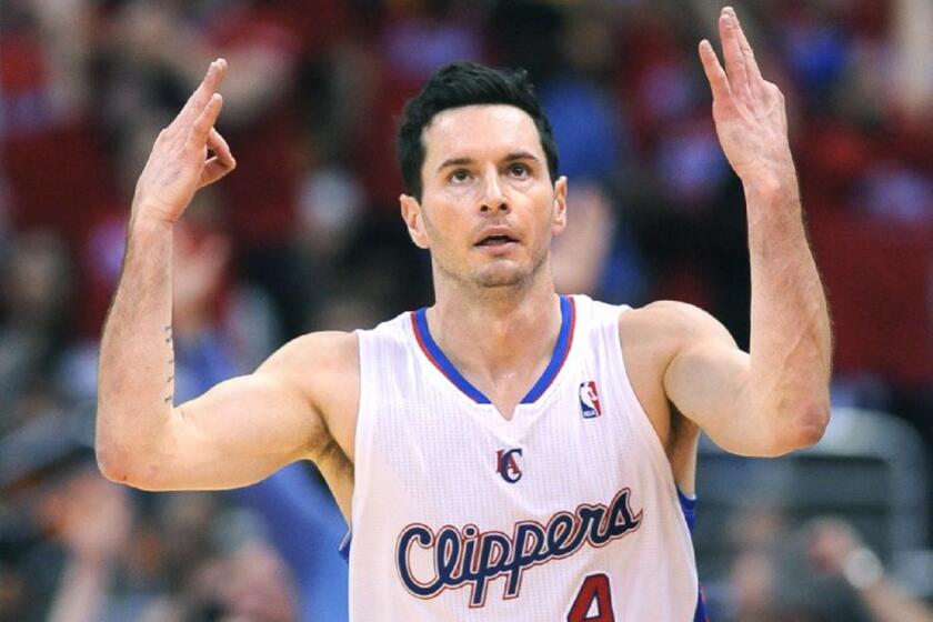 Clippers guard J.J. Redick holds up his hands after hitting a three-pointer against the Golden State Warriors during a 2014 NBA playoff game.