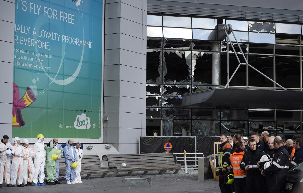 Forensic officers and firefighters gather outside the damaged terminal at Brussels Airport on Wednesday.