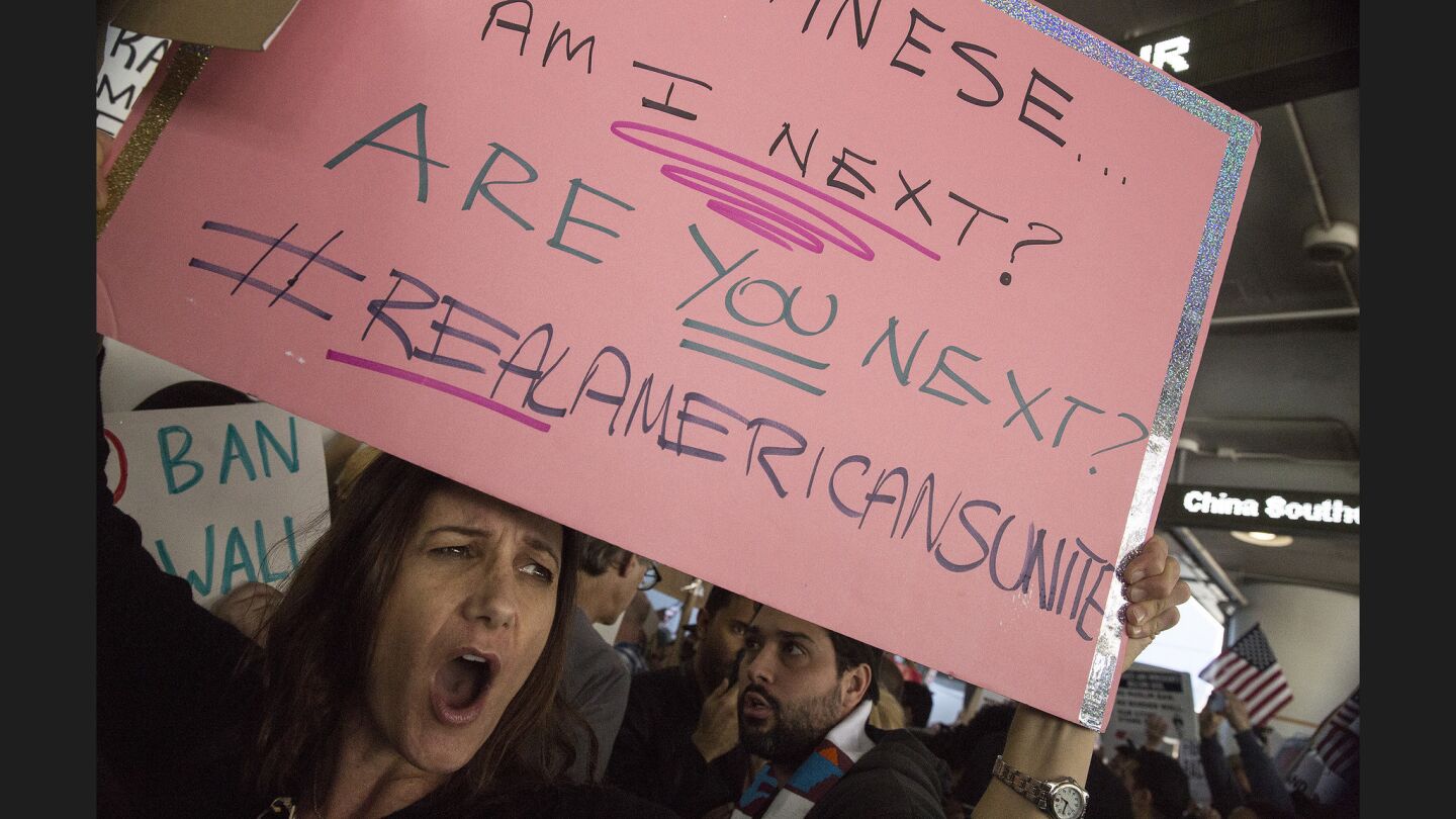 A protester holds up sign at the Tom Bradley International Terminal.