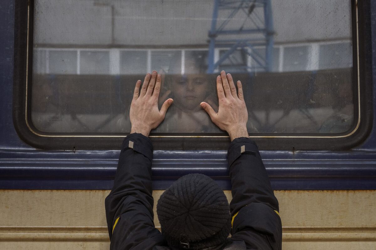 Aleksander, 41, presses his palms against the window as he says goodbye to his daughter Anna, 5, on a train to Lviv at the Kyiv station, Ukraine, Friday, March 4. 2022. Aleksander has to stay behind to fight in the war while his family leaves the country to seek refuge in a neighbouring country. (AP Photo/Emilio Morenatti)
