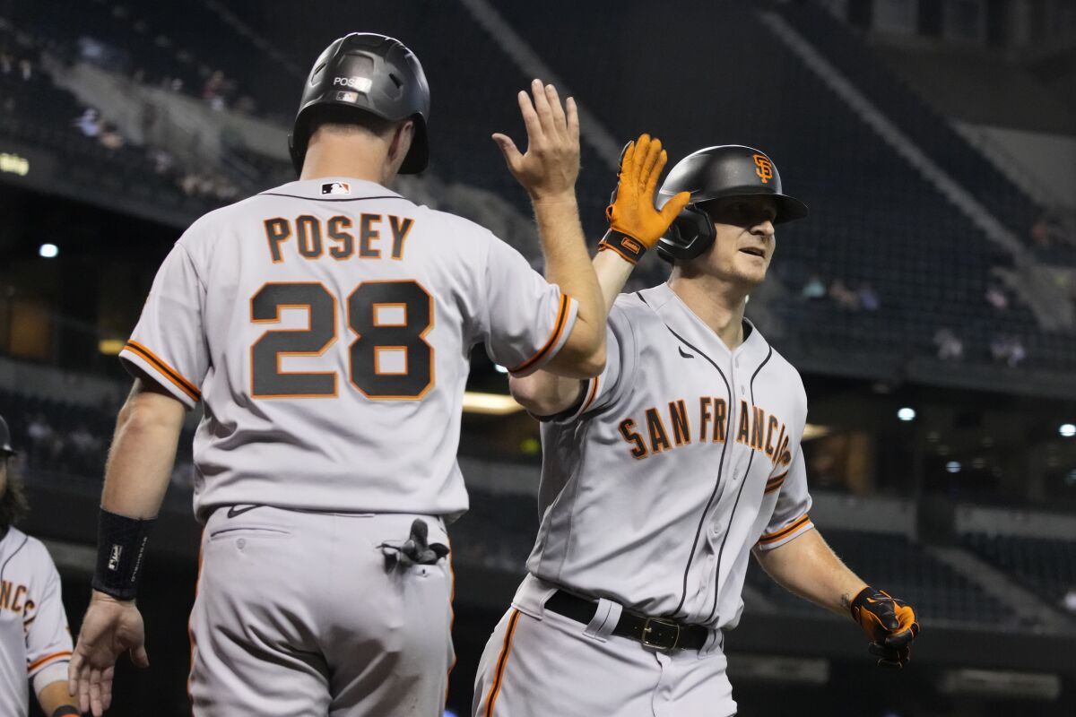 San Francisco Giants' Alex Dickerson, right, celebrates with Buster Posey (28) after hitting a grand slam against the Arizona Diamondbacks in the fifth inning during a baseball game, Monday, Aug 2, 2021, in Phoenix. (AP Photo/Rick Scuteri)